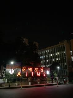 people are standing in front of a building at night with the lights on and there is a sign that says atms