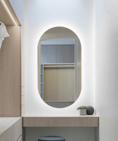 a bathroom with a round mirror and stool