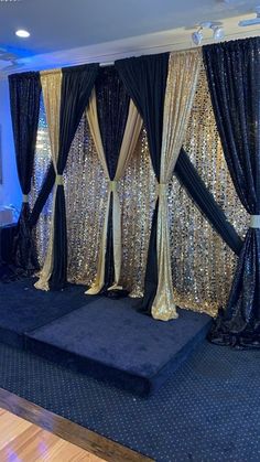 a stage set up with black and gold sequins on the curtained walls