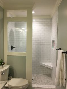 a white toilet sitting next to a walk in shower