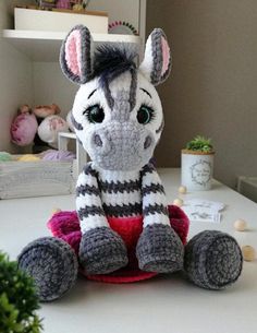 a stuffed zebra sitting on top of a table