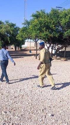 two men are playing frisbee in the dirt