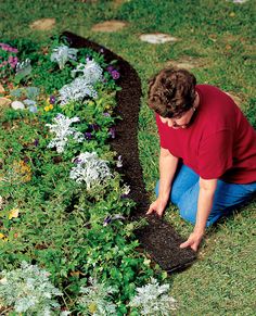 a person kneeling down in the grass with some plants growing out of it and dirt on the ground