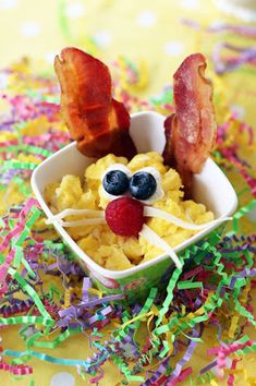 a bowl filled with cereal and bacon on top of a table covered in confetti