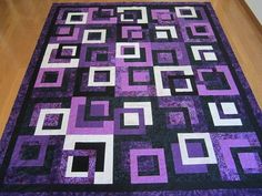 a purple and black quilt with squares on it