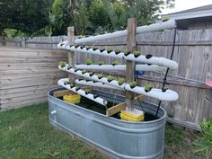 a large metal tub filled with lots of water and plants on top of wooden boards