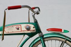 an old green bicycle with a red handlebar