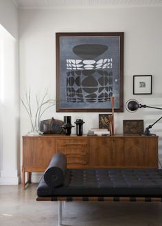 a living room filled with furniture and a painting hanging on the wall over a couch