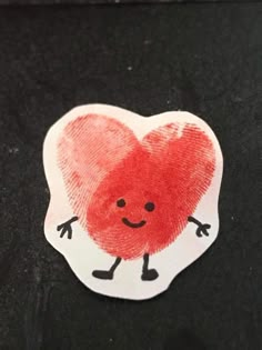 a heart shaped sticker on a black surface