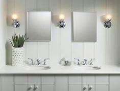 a bathroom with two sinks and three mirrors