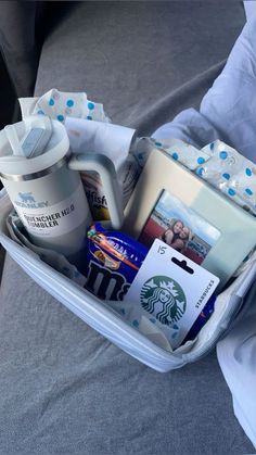 an open suitcase filled with personal items on top of a bed in someone's lap