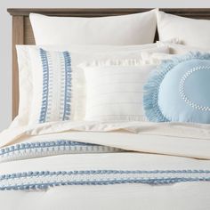 a bed with blue and white pillows on top of it