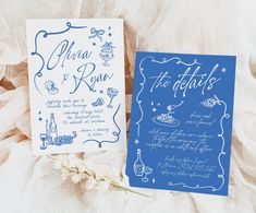 two blue and white wedding stationery cards on top of each other with flowers in the background