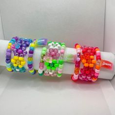 "Glitter/iridescent Kandi bracelet 3-piece sets come in a variety of fun, bright colors! Bracelet lengths vary from 7 to 8 inches so they're perfect to stack!  Each Kandi bracelet pack includes the following: * Flower cuff bracelet  * Single bracelet + \"Sweet\" candy bag charm  * Single bracelet + gummy bear charm  All items are hand-made on elastic jewelry string and triple-knotted to ensure the best stretch and durability. As a thank you, every order also includes FREE GIFTS! (Bigger orders = bigger gifts 😊)" Kandi Designs, Elastic Jewelry, Flower Cuff Bracelet, Flower Cuff, Single Bracelet, Bracelet Pack, Bracelet Sets, Kandi Bracelets, Bead Ideas