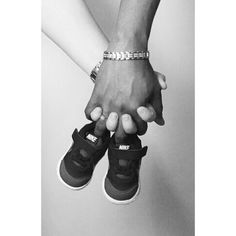 black and white photograph of two people holding each other's hands with their feet