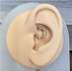 a close up of a fake ear on top of a white plate with an object in the background