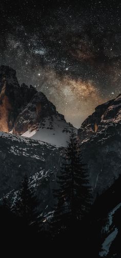 the night sky is filled with stars above mountains