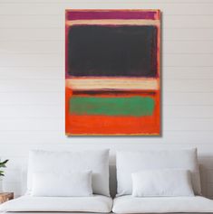 an abstract painting hangs on the wall above a white couch in a room with two pillows