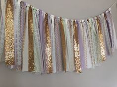 there is a gold and purple streamer hanging from the wall with sequins on it