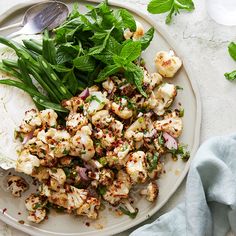 a white plate topped with cauliflower and greens