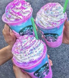 three drinks with sprinkles on them are being held by two persons'hands