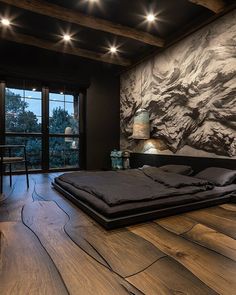 a bedroom with wood flooring and large painting on the wall next to it's bed