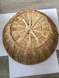 a round wicker basket sitting on top of a piece of paper