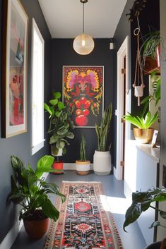 a hallway with potted plants and pictures on the wall, along with a rug