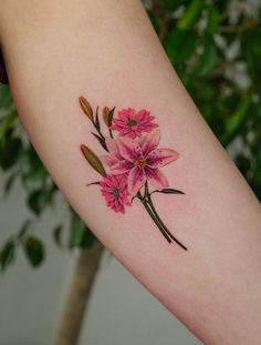 a pink flower tattoo on the left arm