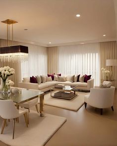 a living room filled with furniture and a chandelier above a glass top table