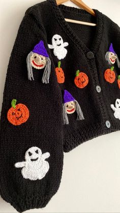 a black sweater with ghost and pumpkins on it