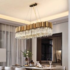 a dining room table with white chairs and a chandelier hanging from the ceiling