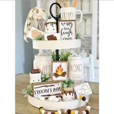 there is a three tiered cake decorated with coffee mugs and other items on it