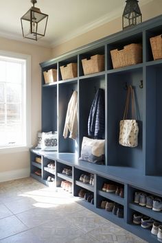 a room filled with lots of blue shelves and baskets on top of each shelf next to a window