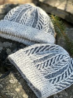 two knitted hats sitting on top of rocks