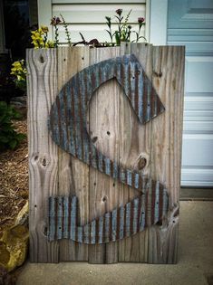 a sign made out of wood with the letter s painted on it's side