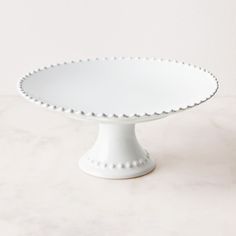 a white cake plate sitting on top of a table