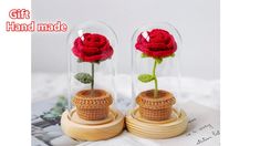 two red roses are placed inside glass domes on top of each other, with the words gift handmade written below them