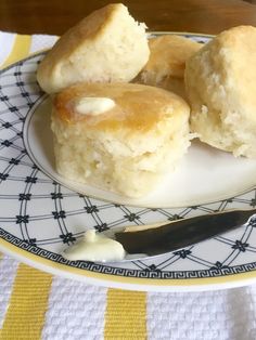 three biscuits on a plate with a knife