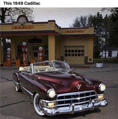 an old car parked in front of a gas station