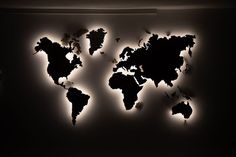 a black and white photo of the world on a wall with light coming from it