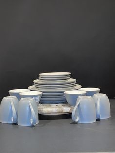 a stack of plates and cups sitting on top of a table