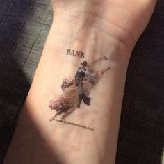 a person with a tattoo on their wrist that says bank and a cowboy riding a horse