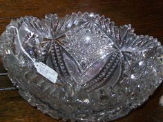 a clear glass bowl sitting on top of a wooden table with a price tag attached to it