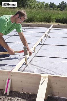 a man working on the roof of a house with cement poured in front of him