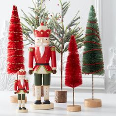 wooden nutcrackers and christmas trees in front of a mirror