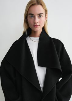 Signature coat crafted from TOTEME's soft doublé fabric – a blend of responsibly sourced wool and cashmere created by hand-stitching two fine layers together to achieve a double-faced finish with clean seams. It has an oversized silhouette with easy-to-style shawl lapels, dropped shoulders, and an open front which makes it perfect for layering, then is complete with inseam pockets and side slits. Coordinate it with the Long doublé scarf in the same color. Oversized Wool Outerwear With Shawl Collar, Black Cashmere Wool Coat For Winter, Winter Black Cashmere Wool Coat, Black Cashmere Wool Coat For Fall, Cashmere Outerwear With Shawl Collar For Winter, Fall Cashmere Outerwear With Shawl Collar, Cashmere Notch Lapel Outerwear For Fall, Cashmere Shawl Collar Outerwear For Winter, Luxury Structured Wool Coat For Fall