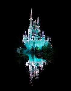 the castle is lit up at night with its reflection in the water and it's lights on