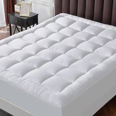 a white mattress sitting on top of a wooden floor