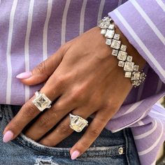 a close up of a person's hand wearing two different rings and bracelets